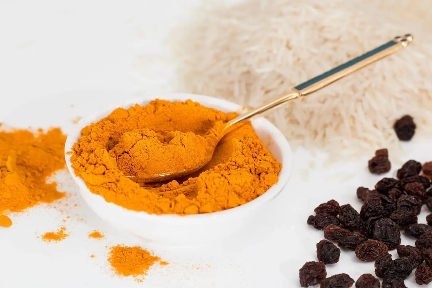 Bowl of turmeric powder with a spoon