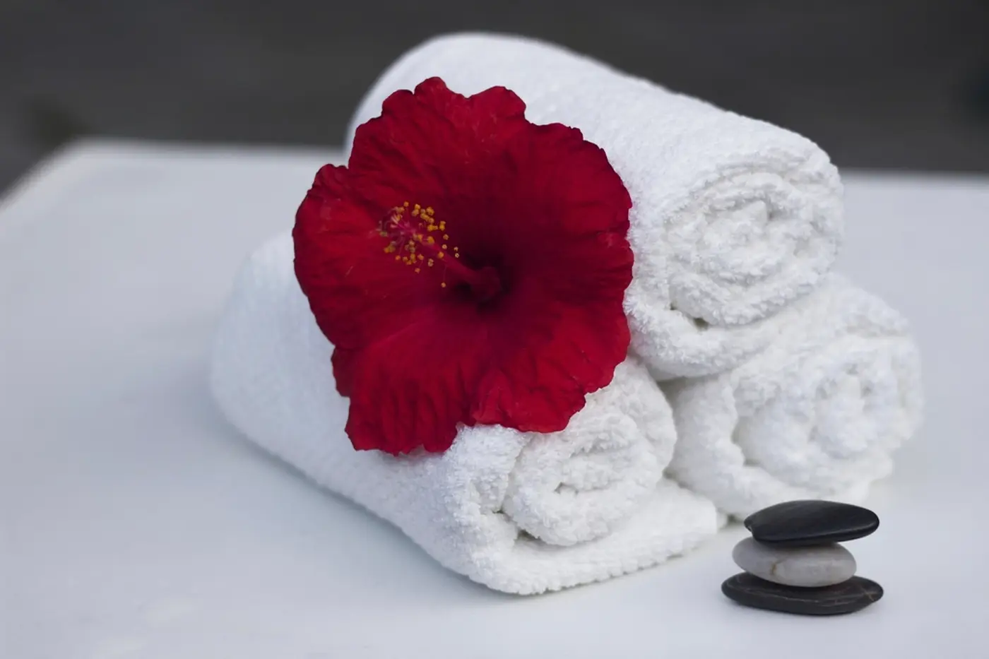 Rolled spa towels with a red flower