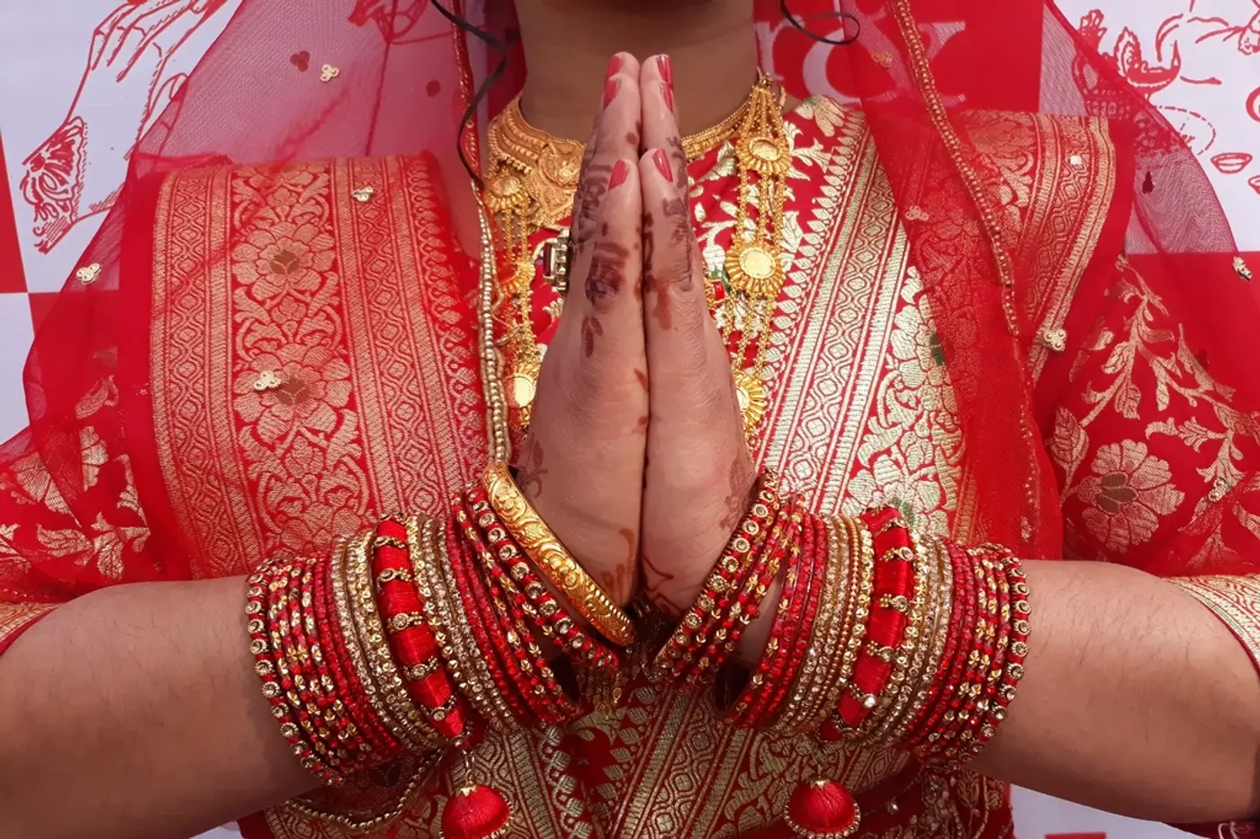 Indian bride in red with bangles and mehndi