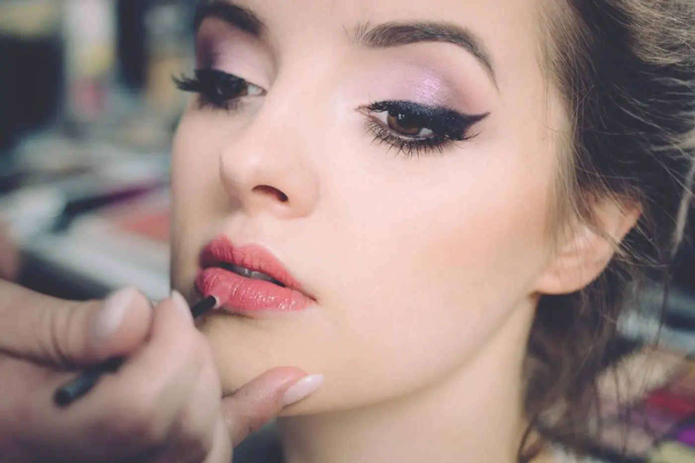 Makeup artist applying lipstick