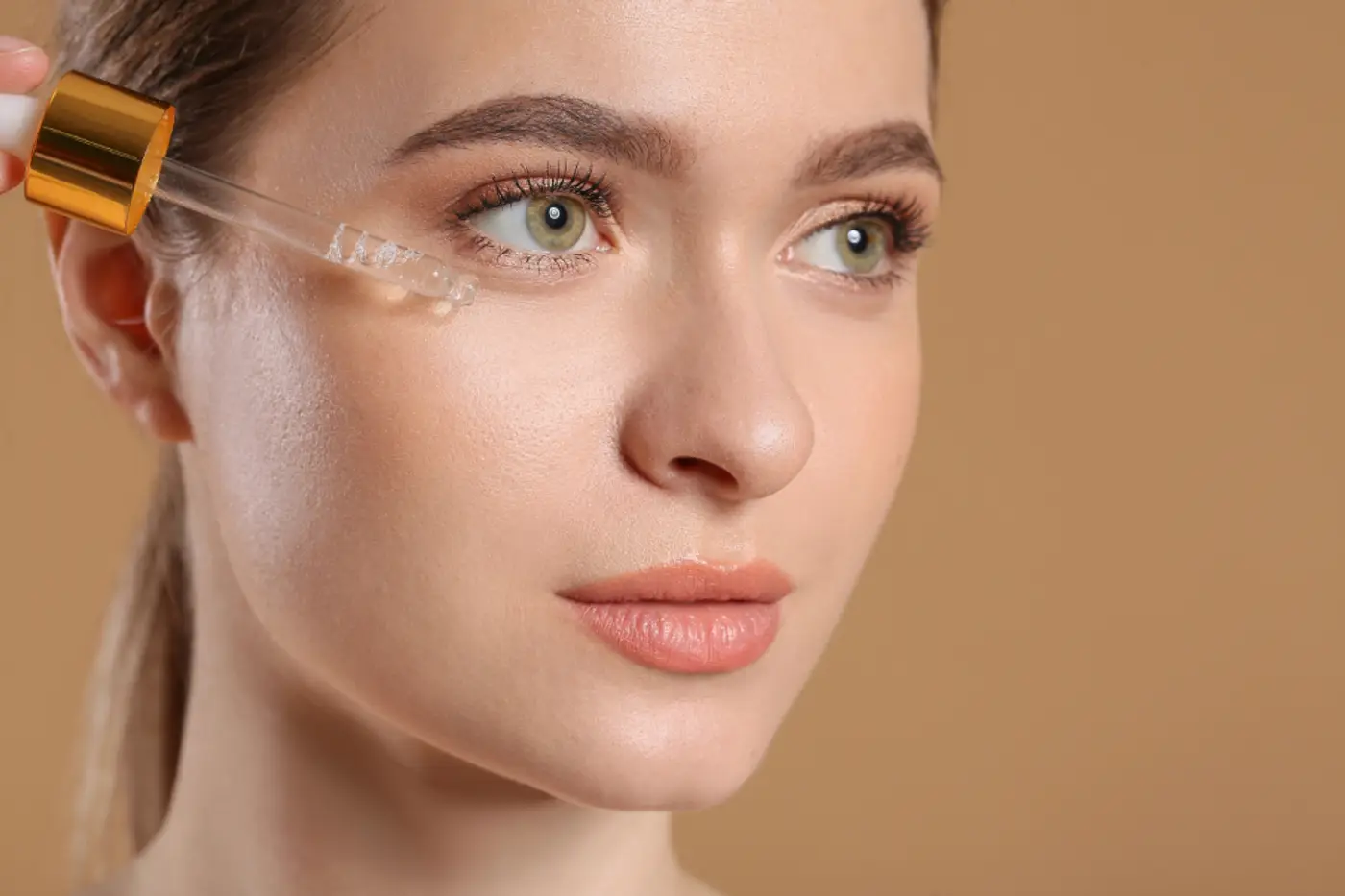 Woman applying a facial serum with a dropper