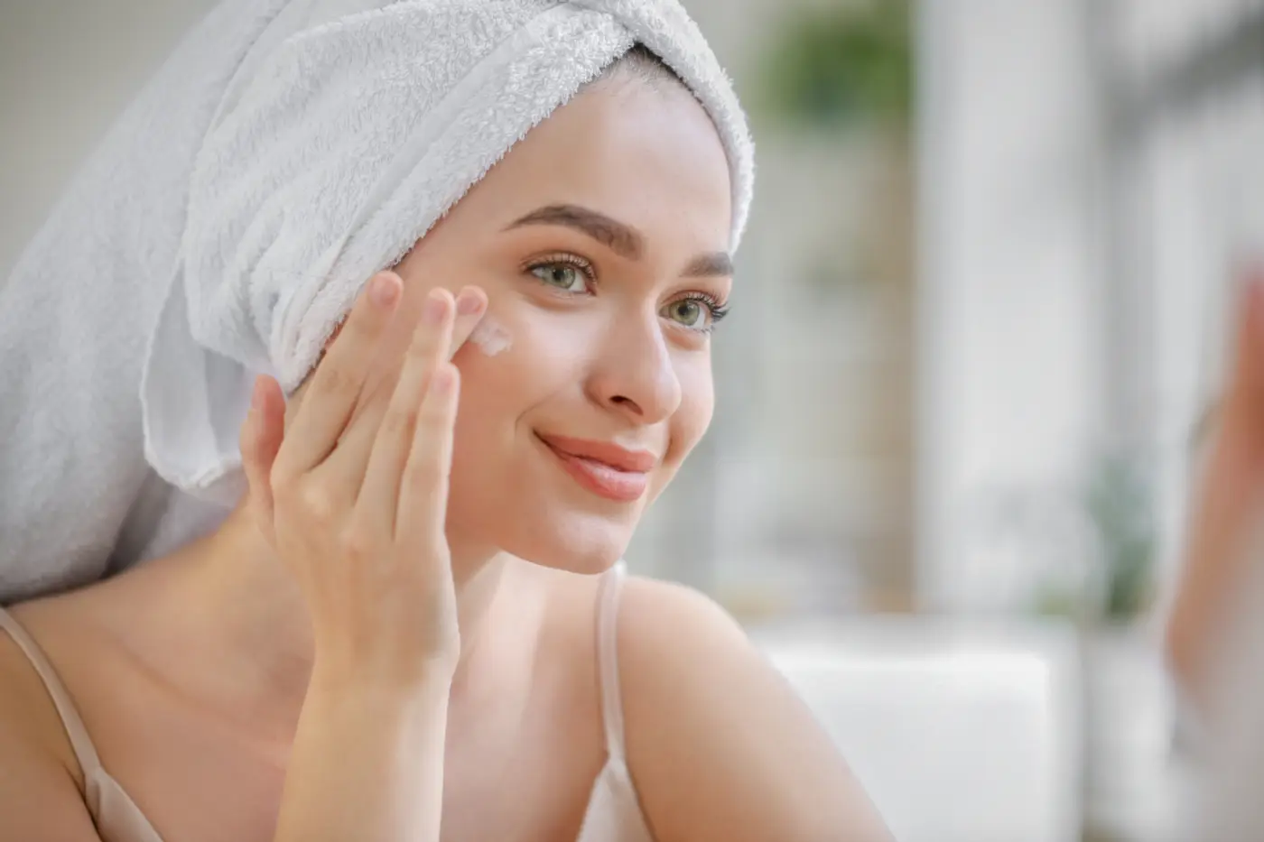 Woman applying a soothing cream to her face