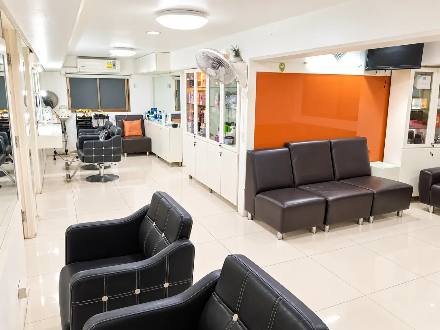 Sai Meher salon: styling stations, product cabinets and the orange waiting area